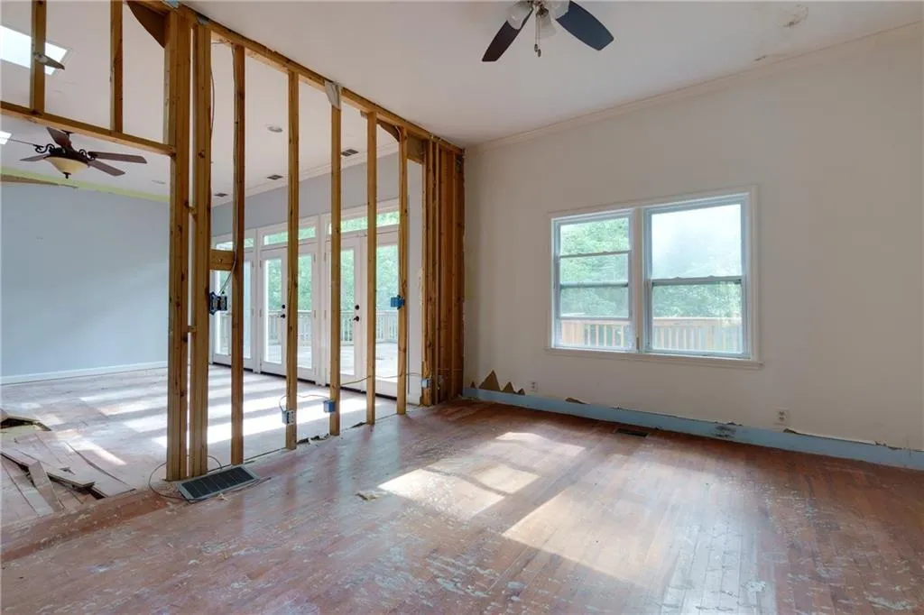 Spare room featuring ornamental molding, ceiling fan, and wood-type flooring