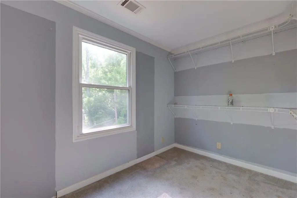 Spare room featuring ornamental molding and light carpet