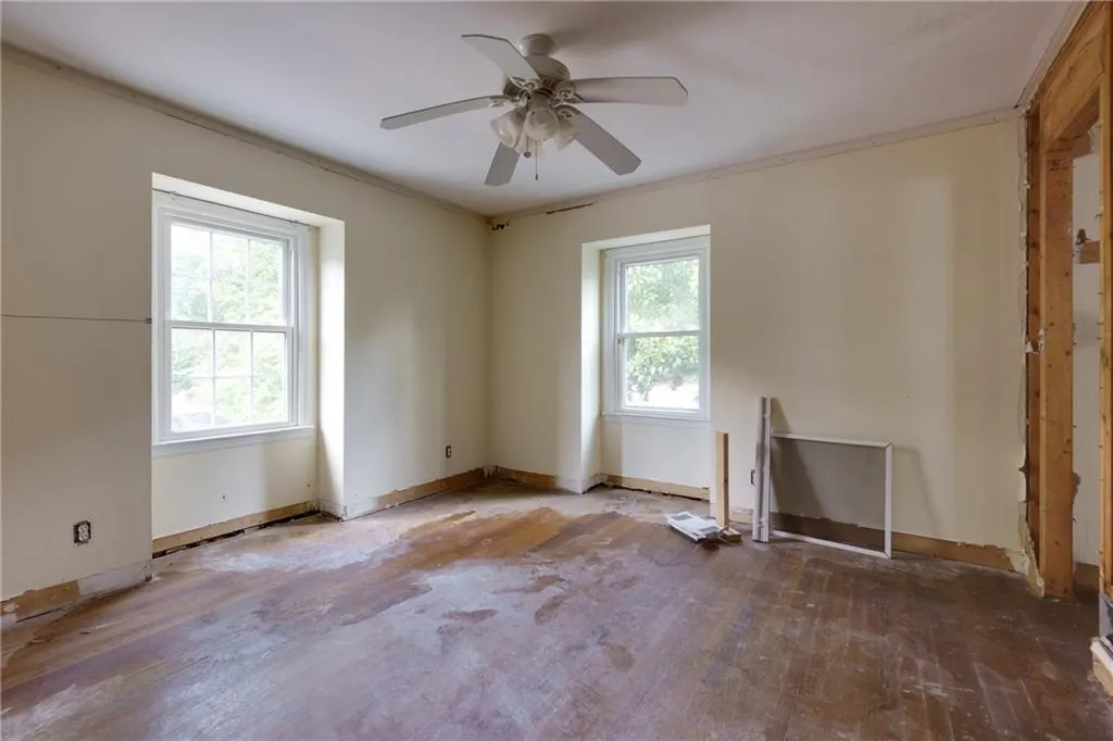 Unfurnished room featuring a ceiling fan, wood finished floors, and crown molding