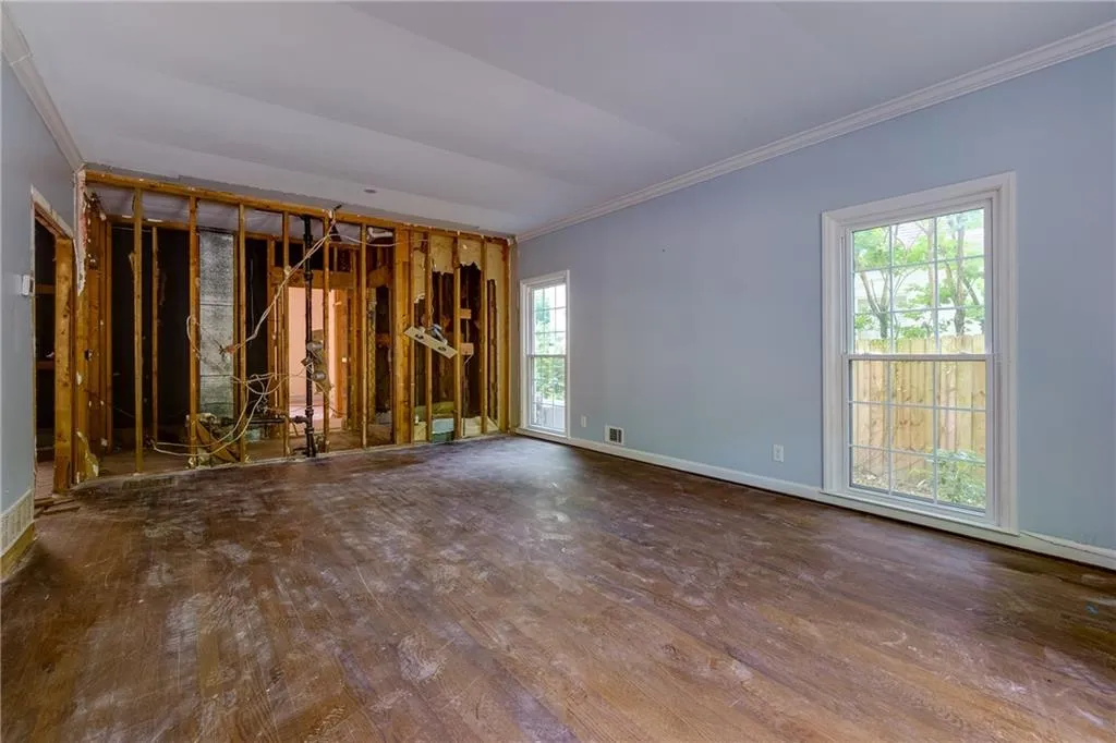 Spare room featuring ornamental molding and wood finished floors