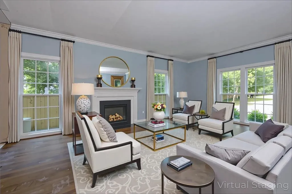 Living room with plenty of natural light, wood finished floors, crown molding, and a glass covered fireplace