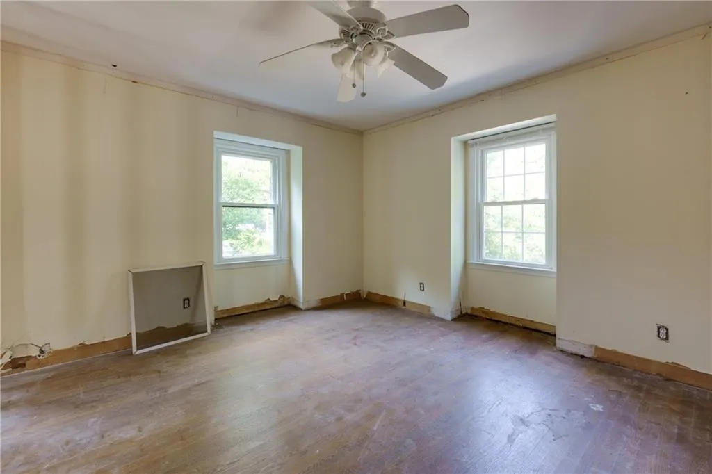 Unfurnished room with wood finished floors and ceiling fan