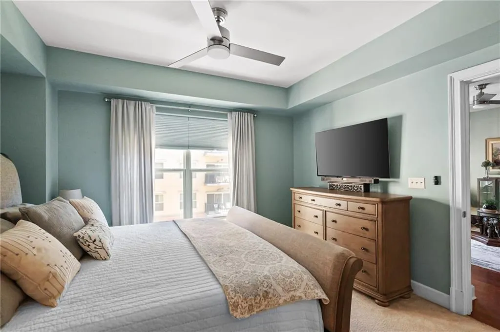 Bedroom with light colored carpet and ceiling fan
