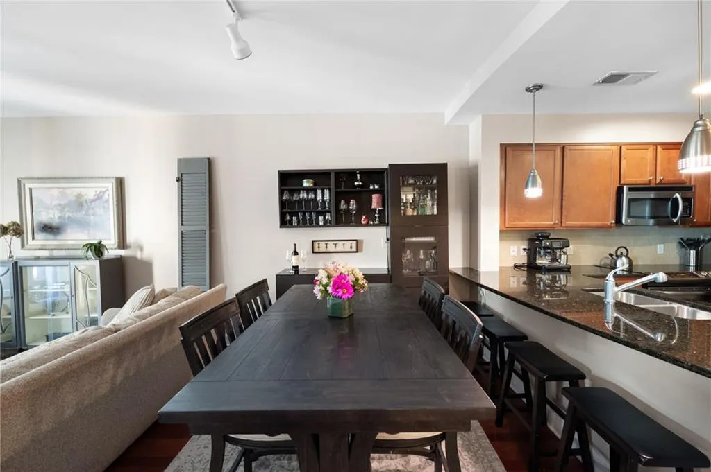 Dining space featuring dark wood-type flooring, rail lighting, and sink