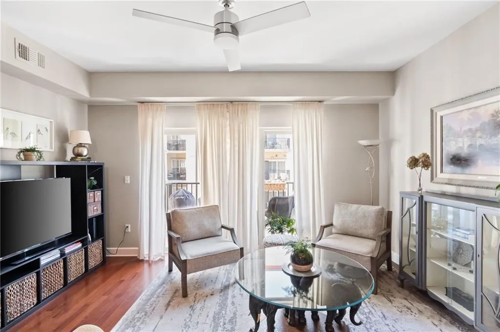 Sitting room featuring ceiling fan, dark hardwood / wood-style floors, and a wealth of natural light