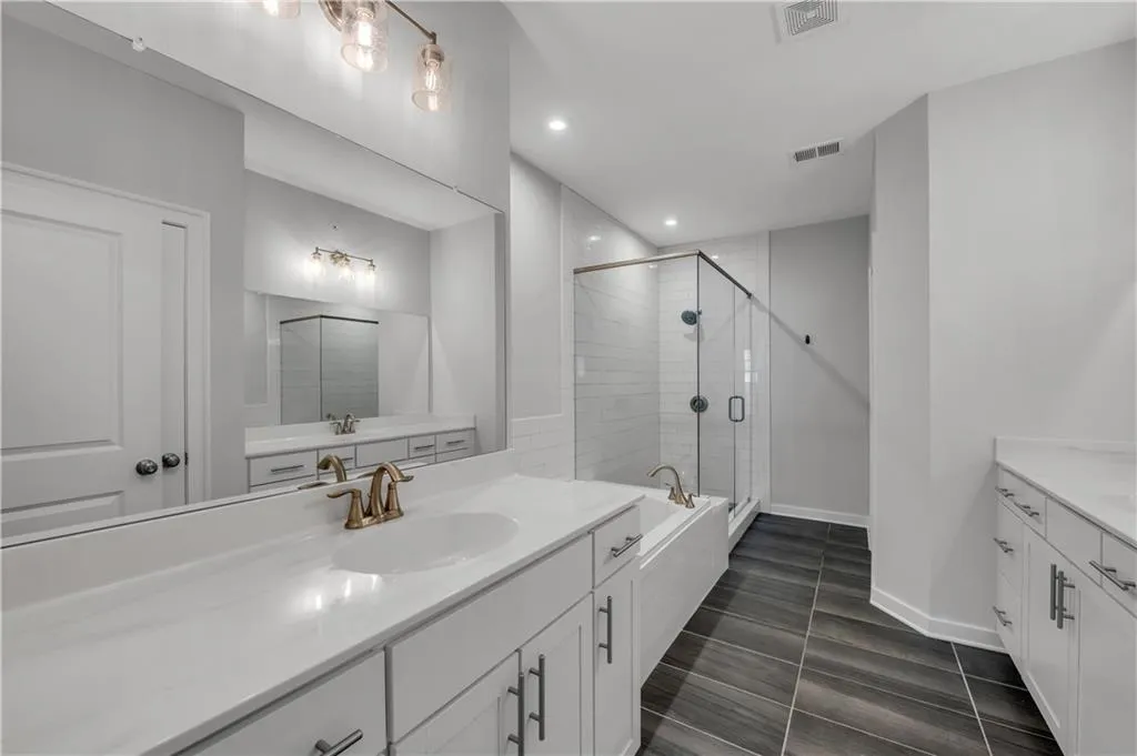 Full bath with vanity, a stall shower, recessed lighting, and a bathtub