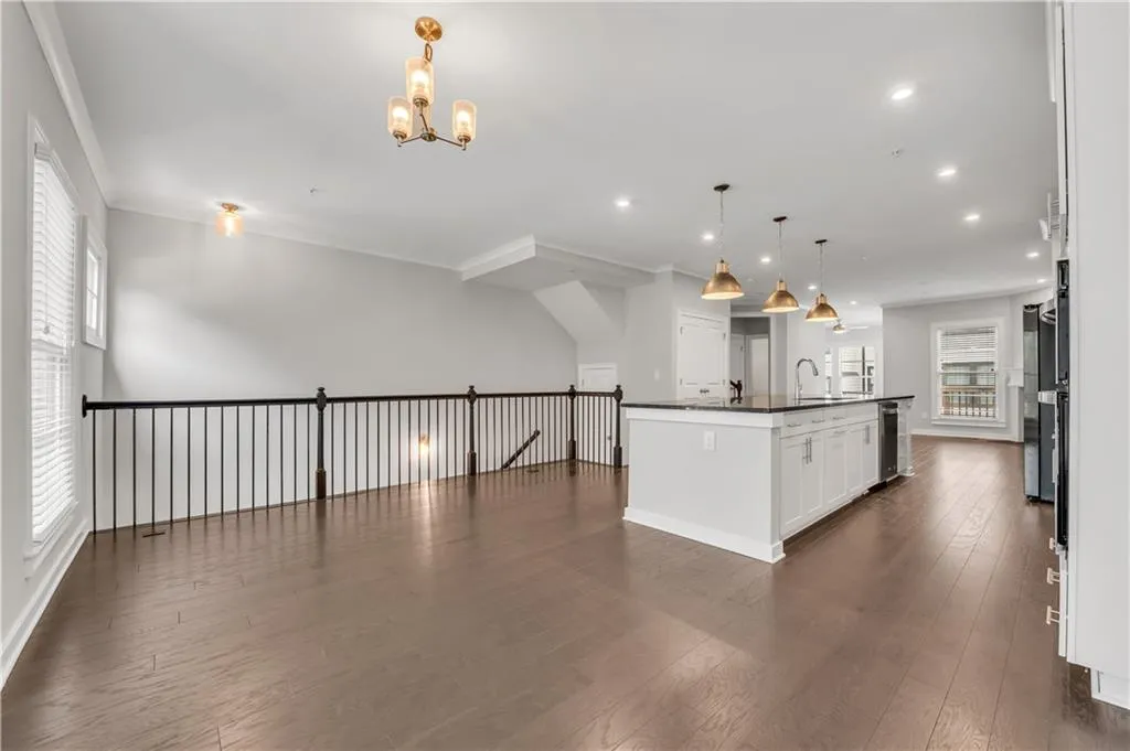 Kitchen featuring open floor plan, dark countertops, a chandelier, healthy amount of natural light, and recessed lighting
