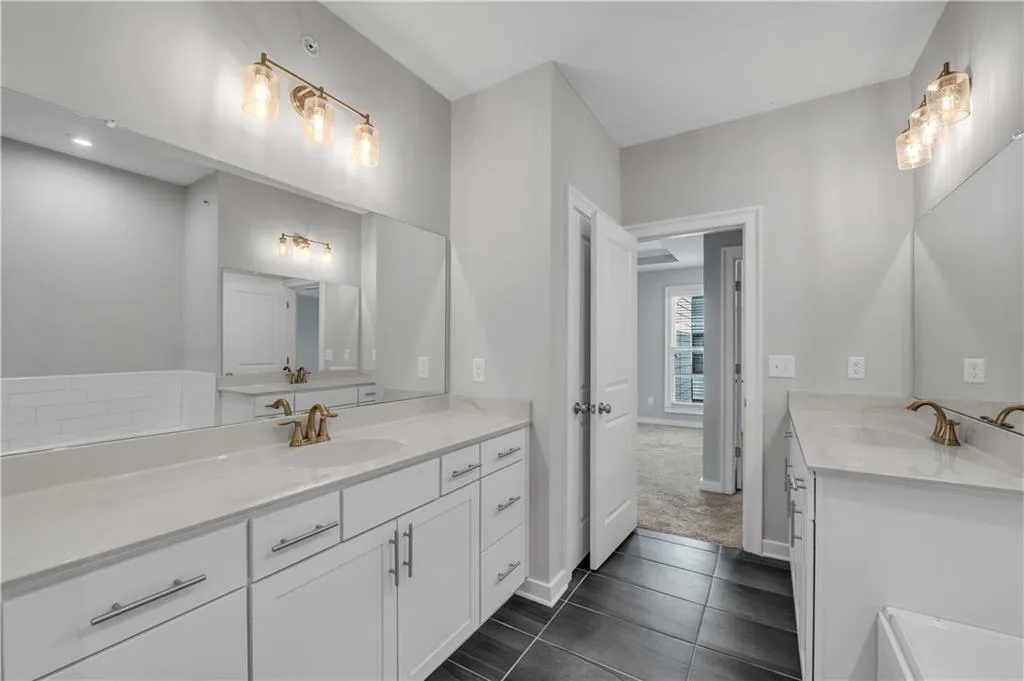 Full bath featuring two vanities and tile patterned floors