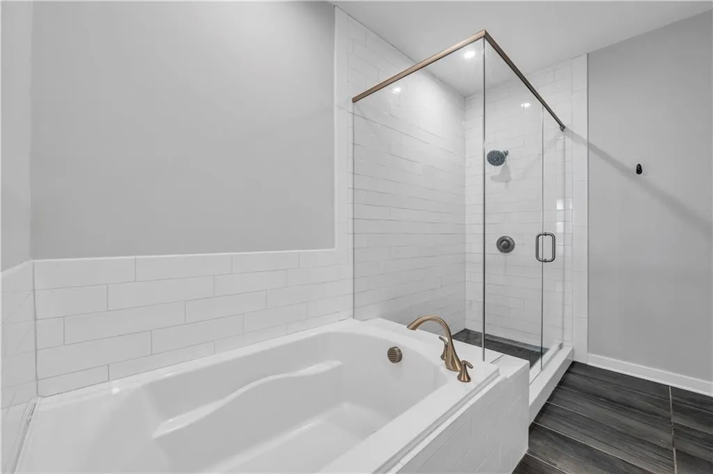 Bathroom featuring a garden tub, a stall shower, and recessed lighting