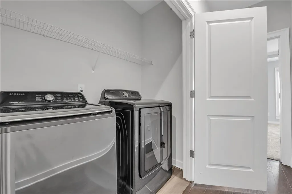 Washroom featuring washer and dryer and wood finished floors