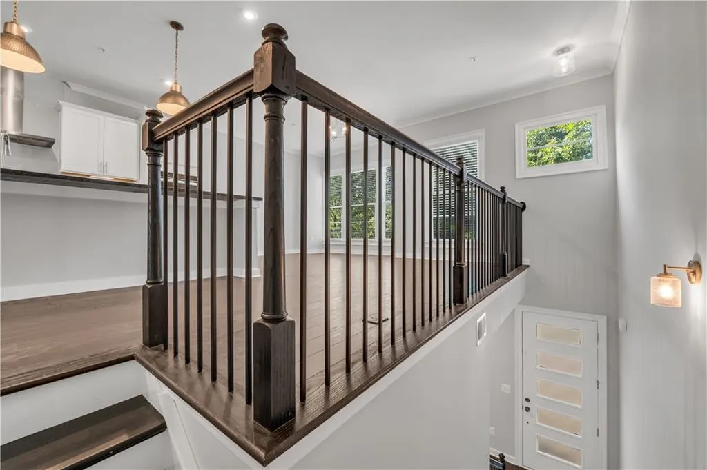 Stairway featuring ornamental molding and wood finished floors