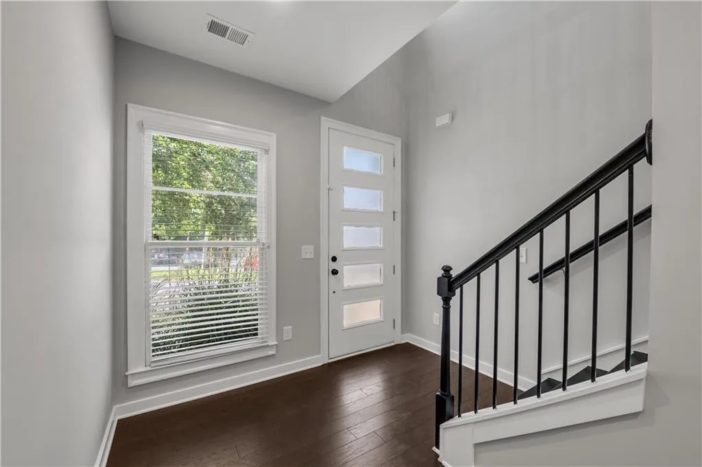 Entrance foyer with dark wood-style floors and stairway