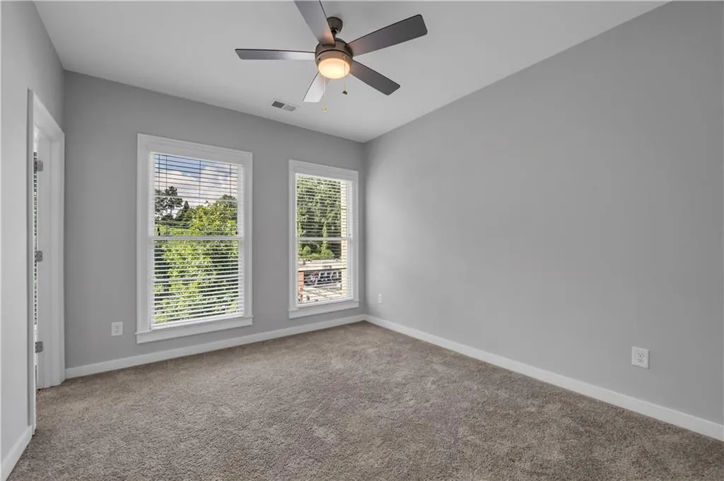 Carpeted spare room with baseboards and ceiling fan