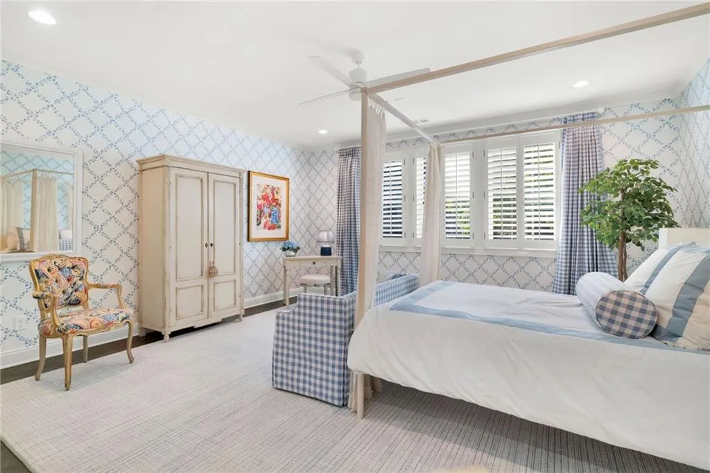 Spacious room featuring patterned wallpaper, plantation shutters, recessed lighting, and a ceiling fan