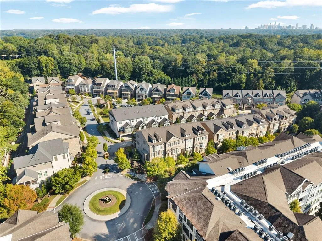 Aerial perspective of residential complex featuring multi-story masonry construction, shingle roofing, paved circular driveways, and mature landscaping