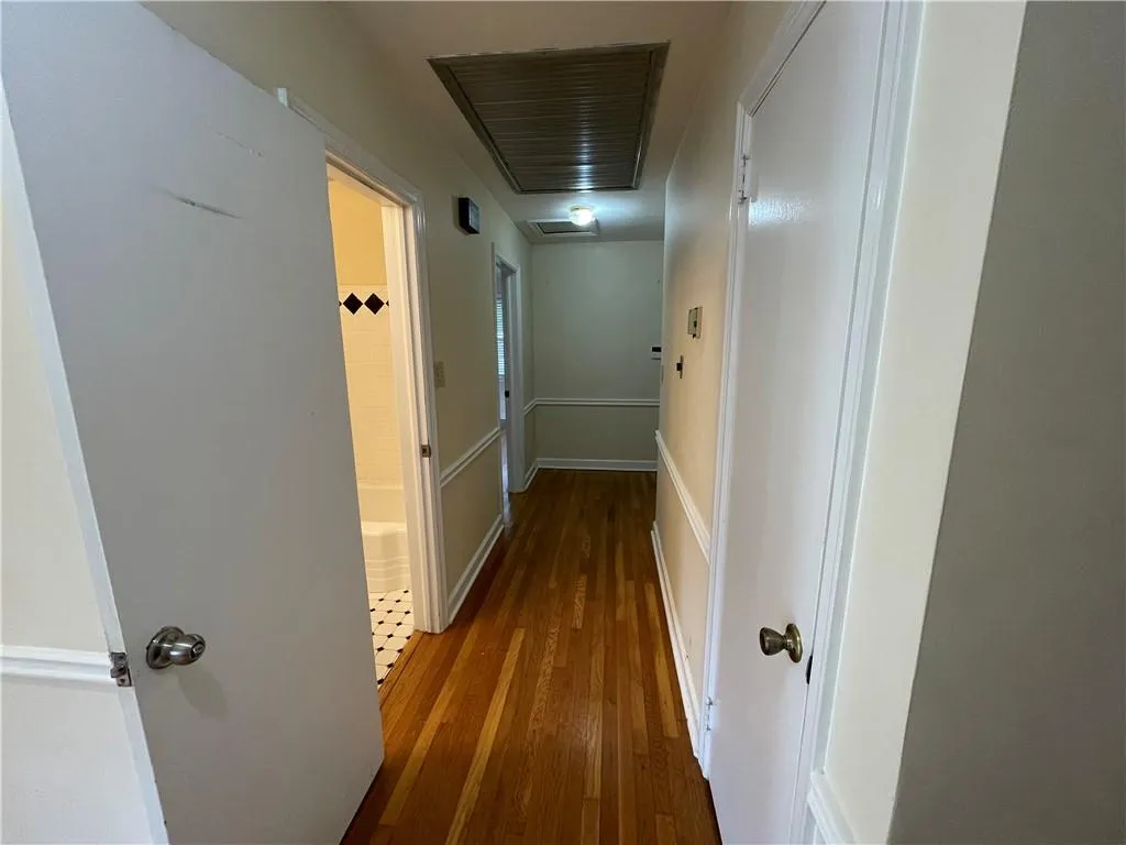 Bedroom wing hallway with whole house fan, attic access and hardwood flooring