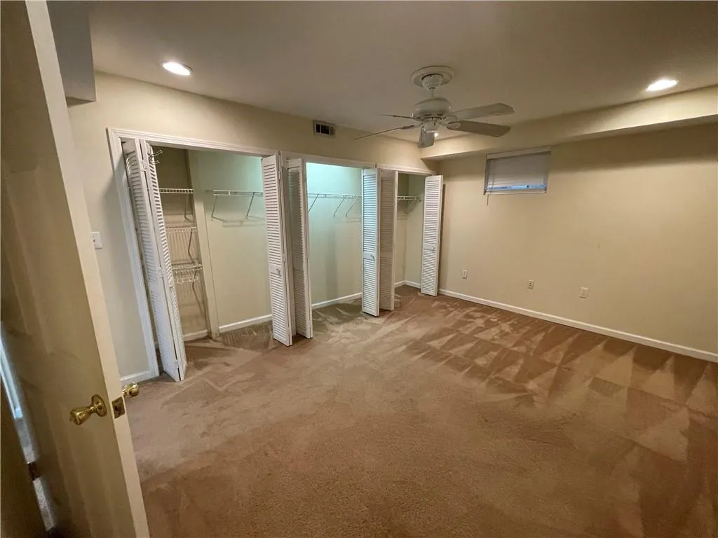 Terrace level bedroom 2 featuring carpet and wall of closets