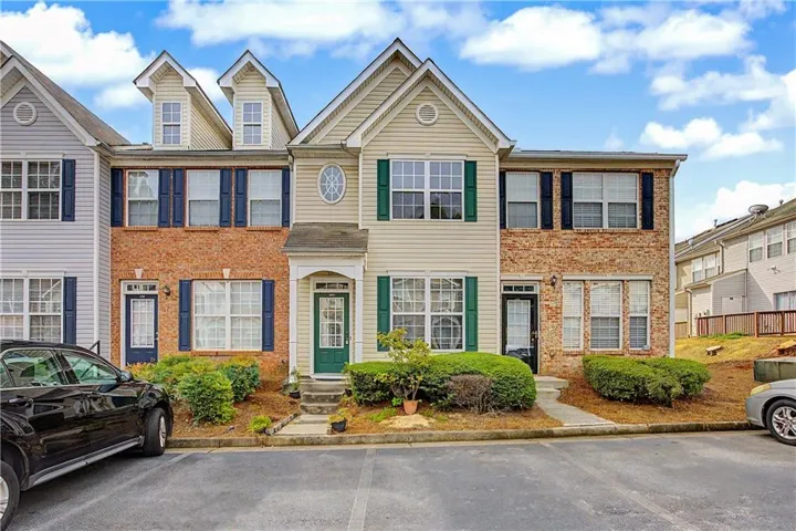 Brick and siding exterior featuring dormer windows, green shutters, and a covered entry
