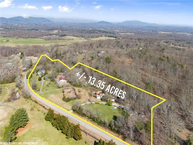 Aerial overview of property's location featuring a mountainous background and property boundaries highlighted