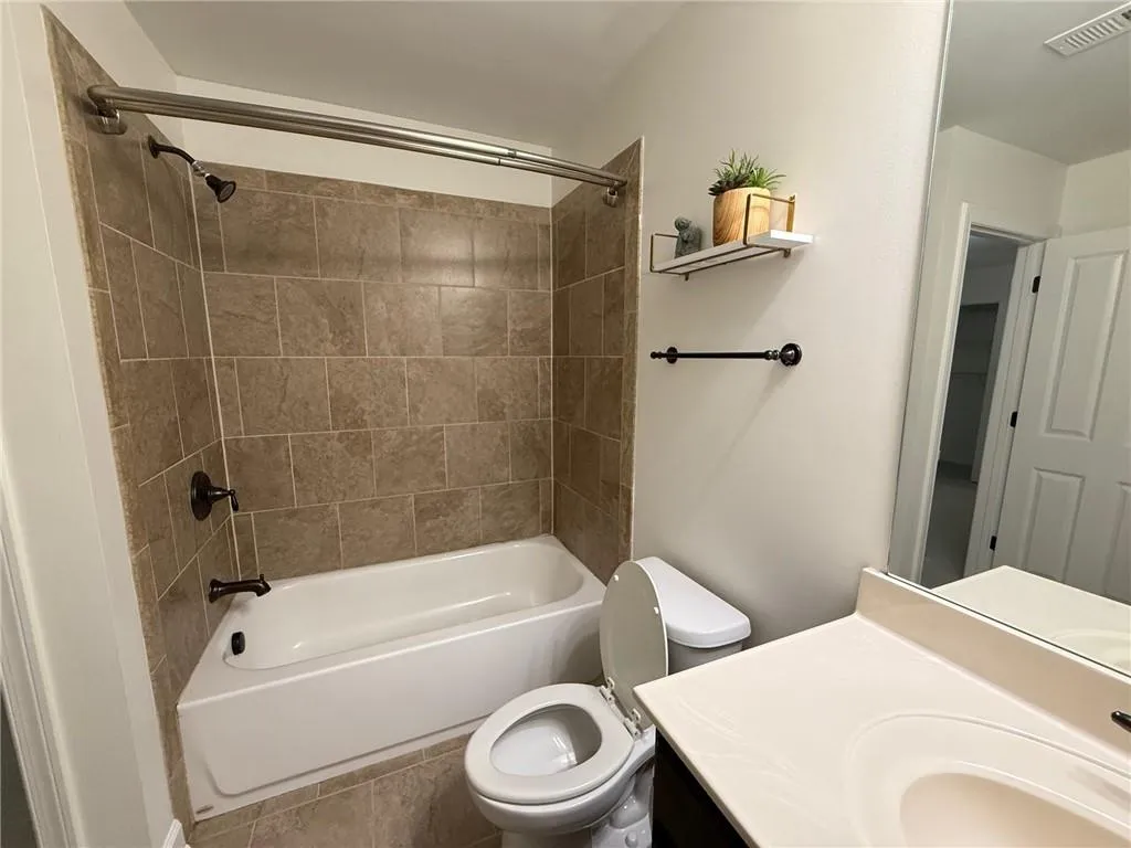 Bathroom featuring shower / washtub combination, vanity, and tile patterned floors