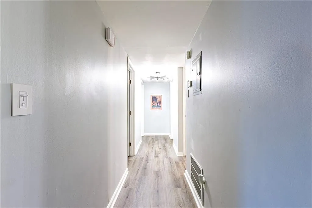 Corridor with light hardwood / wood-style flooring