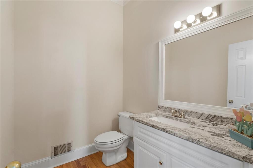 Bathroom with vanity, toilet, and hardwood / wood-style flooring