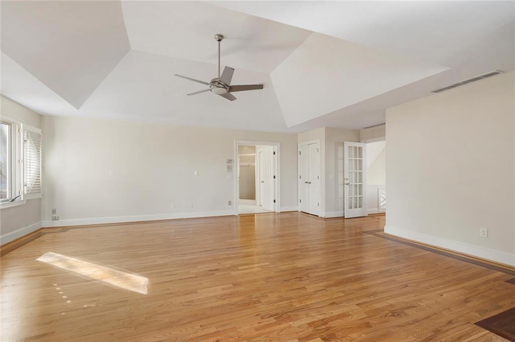 Unfurnished room with ceiling fan, a raised ceiling, and light hardwood / wood-style floors