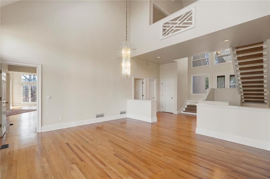 Empty room with a towering ceiling and light wood-type flooring