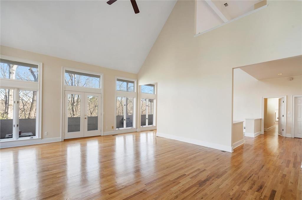 Spare room featuring french doors, ceiling fan, light hardwood / wood-style floors, and high vaulted ceiling