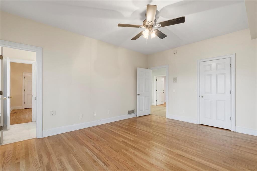 Unfurnished bedroom with ceiling fan and light hardwood / wood-style floors