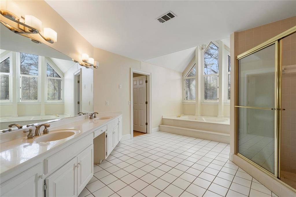 Bathroom featuring a healthy amount of sunlight, tile floors, and double vanity