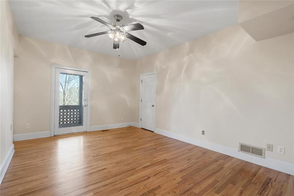 Empty room with ceiling fan and light hardwood / wood-style floors
