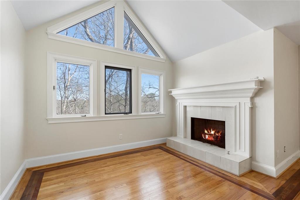 Living room featuring a tile fireplace, light wood-type flooring, and a healthy amount of sunlight