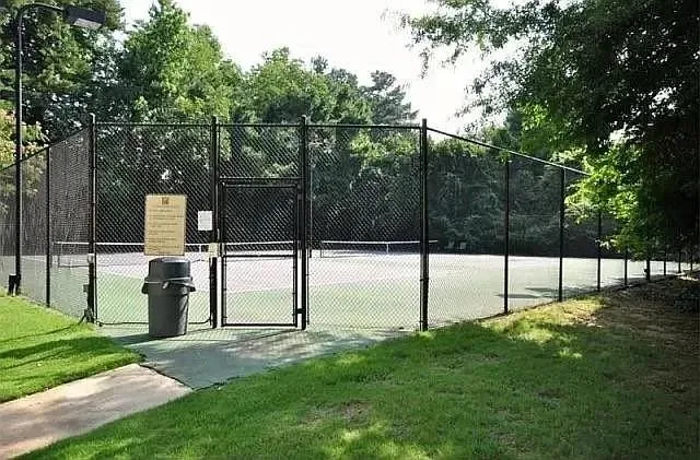 View of tennis court featuring a gate
