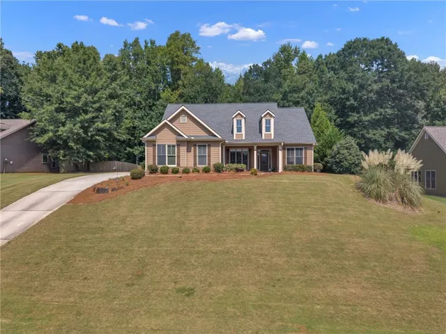 Craftsman-style exterior with dormer windows, a covered front porch, and a paved driveway