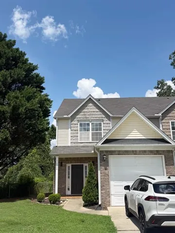 Two-story residence featuring a brick facade, white siding, and a prominent front entry