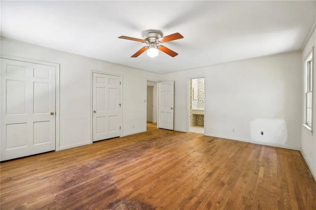 Primary bedroom featuring ensuite bath and multiple closets