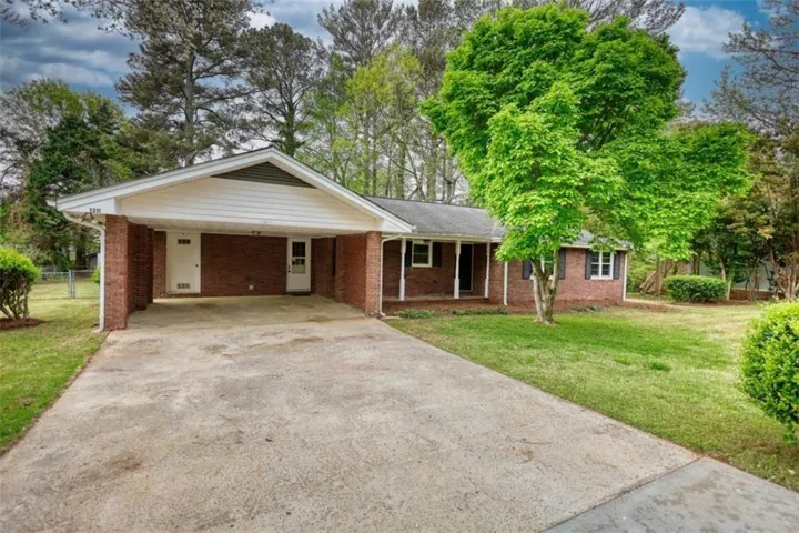 Brick exterior residence featuring a covered carport and a concrete driveway