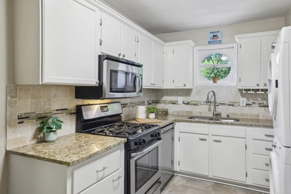 Kitchen boasts White Cabinets, Granite Countertops, and Stainless Steel Appliances