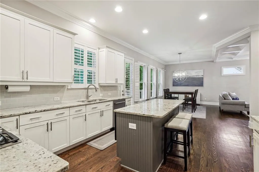 Kitchen with ornamental molding, plenty of natural light, a kitchen bar, backsplash, and a kitchen island