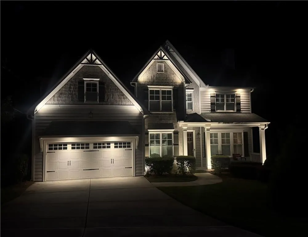 View of front of home with in the evening with custom exterior lighting