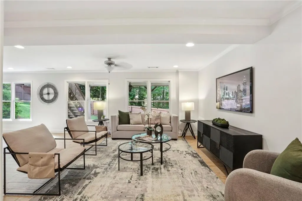 Living room with crown molding, recessed lighting, wood finished floors, ceiling fan, and stairs