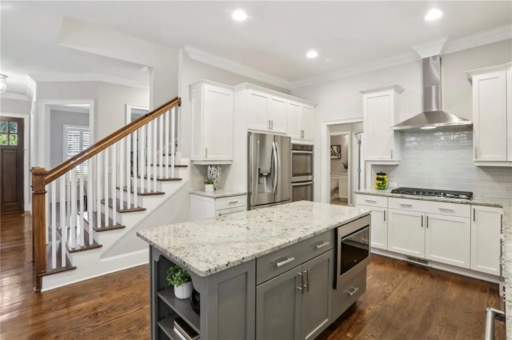 Kitchen featuring white cabinets, light stone countertops, tasteful backsplash, crown molding, and open shelves
