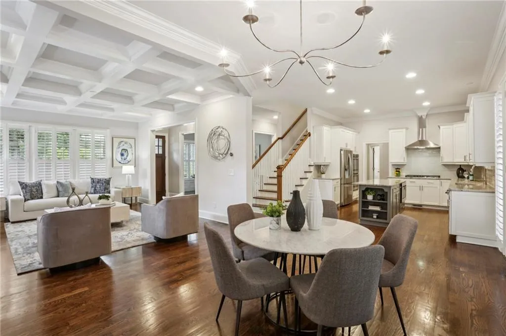 Dinette with  refreshed hardwood flooring, coffered ceiling, stairs, beamed ceiling, and recessed lighting