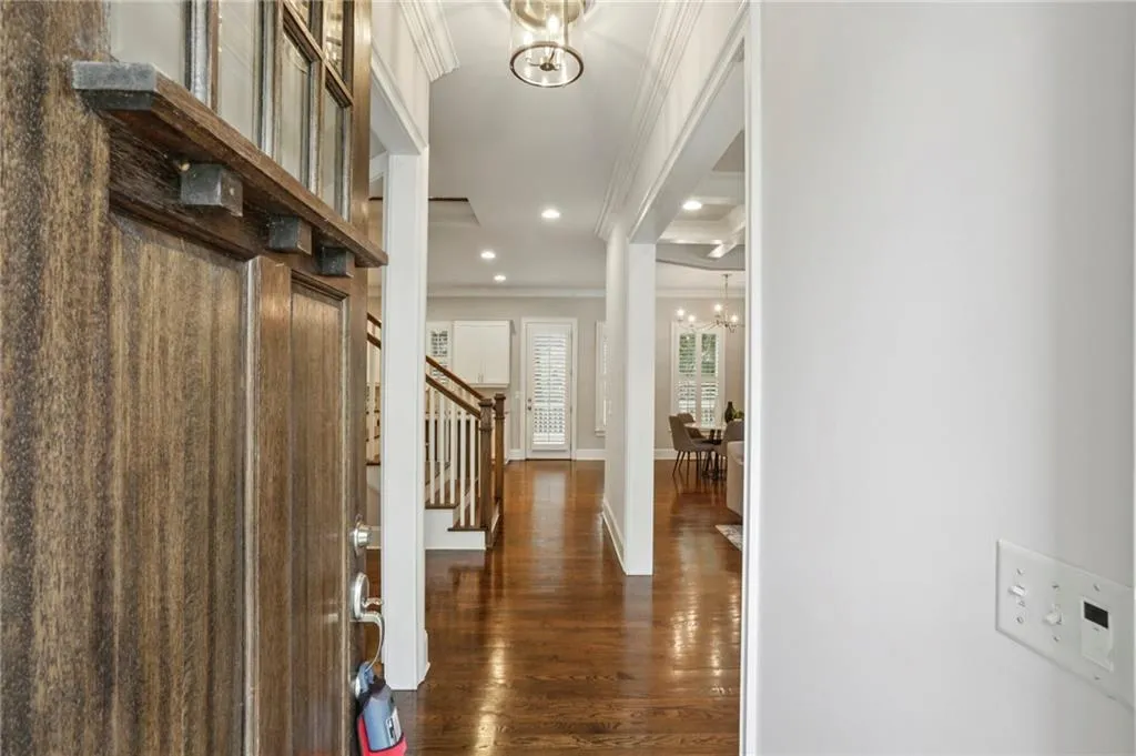 Foyer with a chandelier, dark hardwood flooring, crown molding, stairway, and recessed lighting