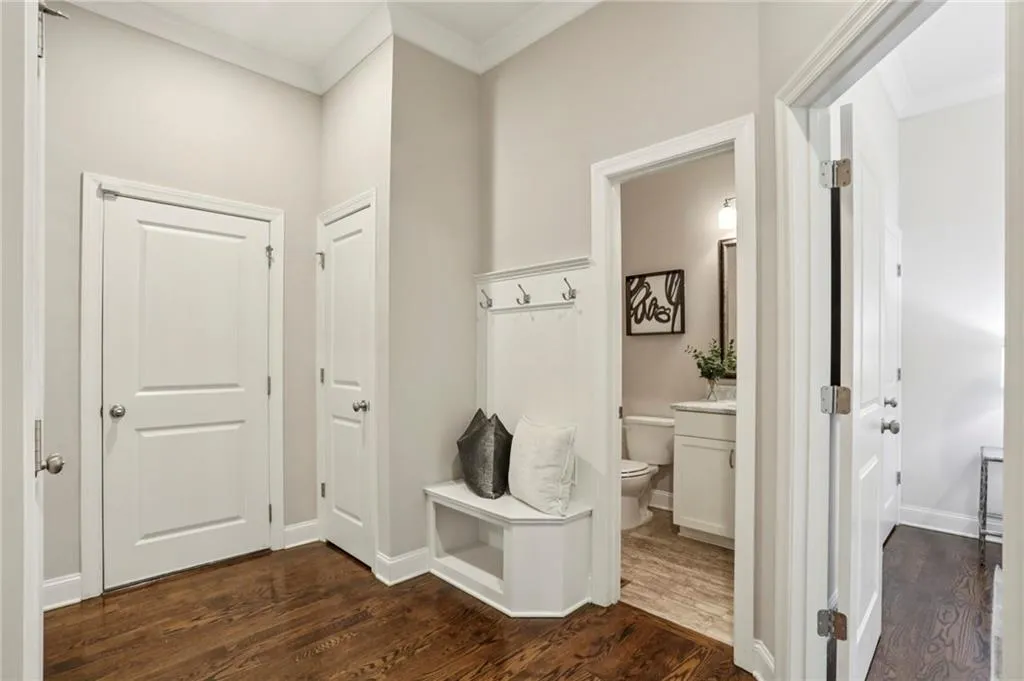 Mudroom featuring ornamental molding and dark wood-type flooring