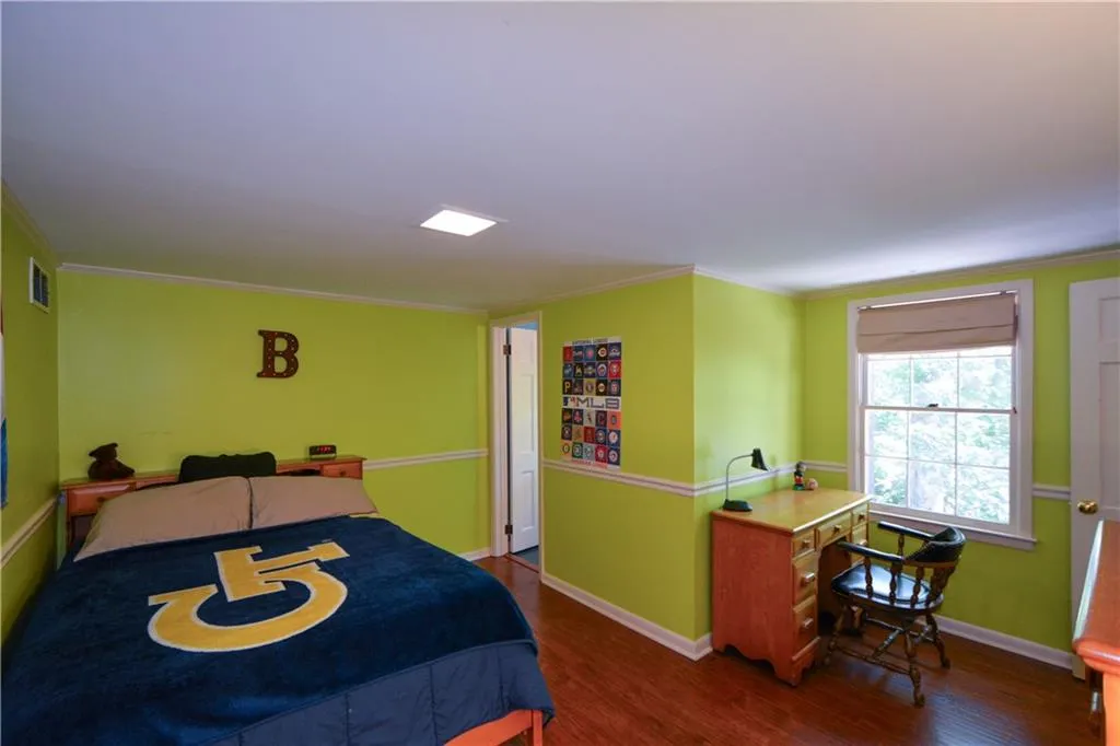 Bedroom featuring ornamental molding and hardwood / wood-style floors Bedroom featuring ornamental molding and hardwood / wood-style floors