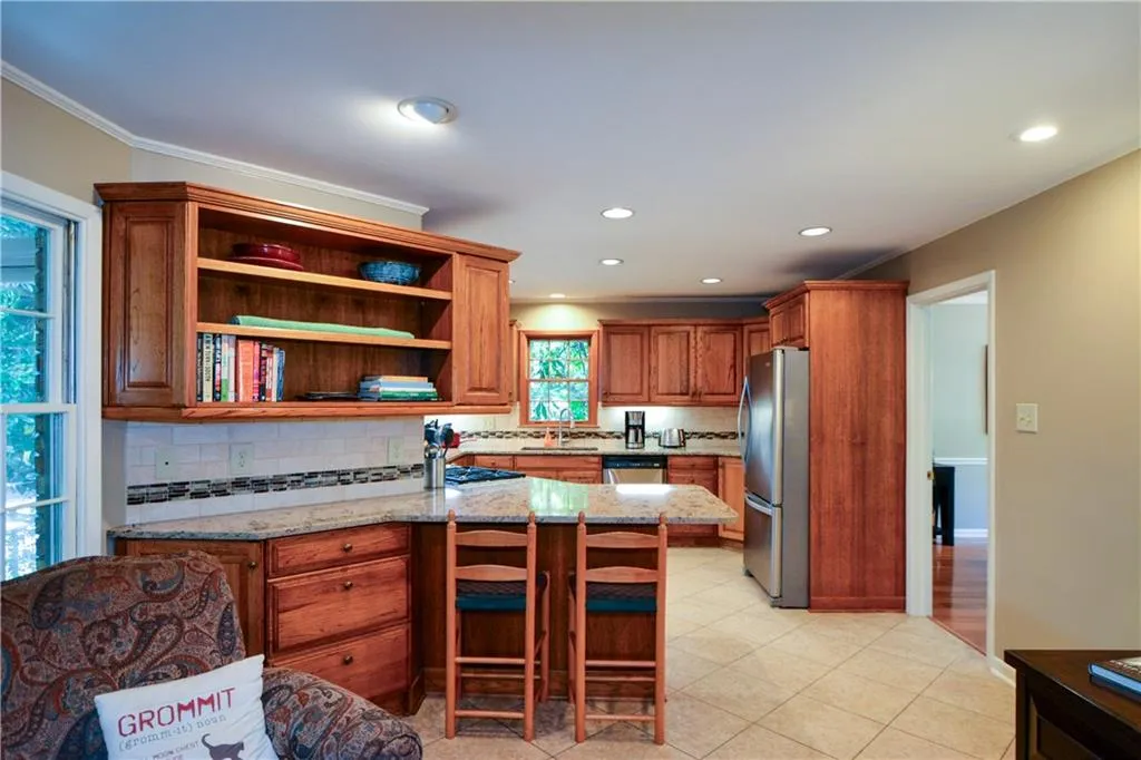 Kitchen featuring light stone countertops, tasteful backsplash, light tile floors, sink, and appliances with stainless steel finishes Kitchen featuring light stone countertops, tasteful backsplash, light tile floors, sink, and appliances with stainless steel finishes