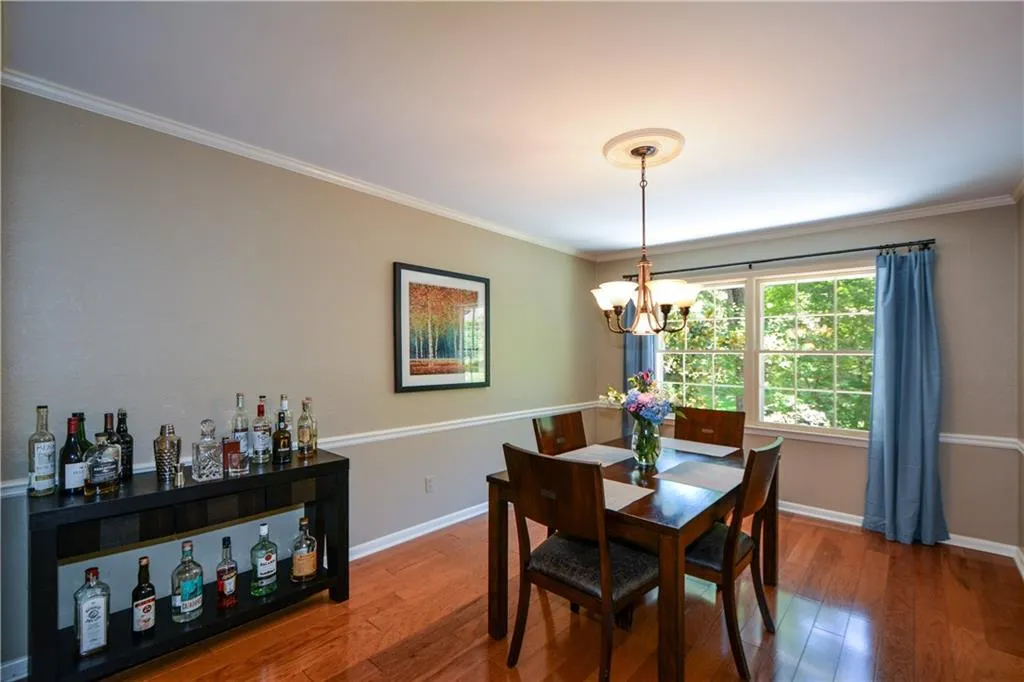 Dining room featuring ornamental molding, hardwood / wood-style floors, and a chandelier Dining room featuring ornamental molding, hardwood / wood-style floors, and a chandelier