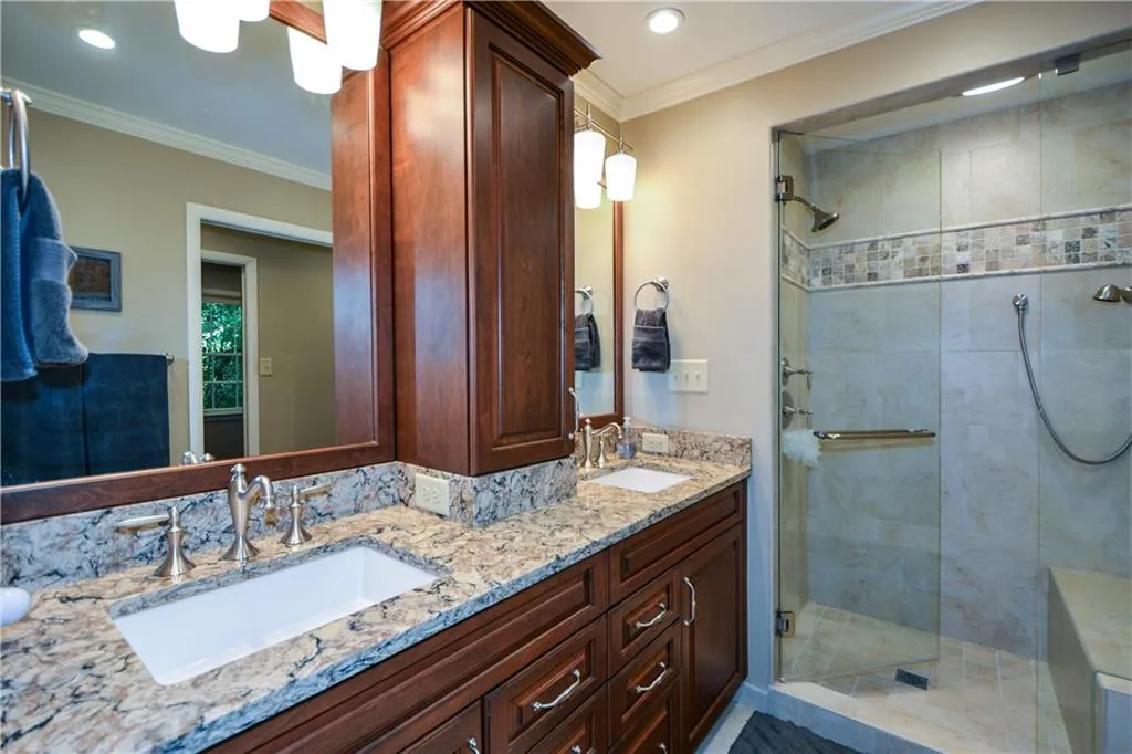 Bathroom with walk in shower, ornamental molding, and double sink vanity Bathroom with walk in shower, ornamental molding, and double sink vanity